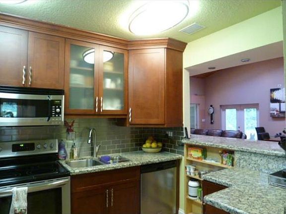 Updated cherry cabinets with granite counters, tile backspla