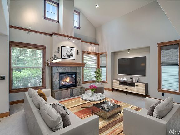 Inviting open living room with soaring ceiling, gas fireplace and recessed TV nook.