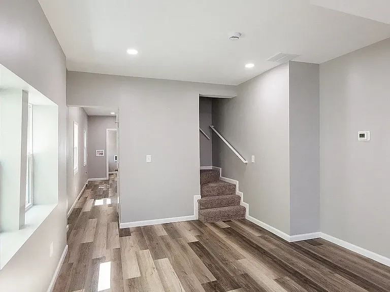 Living room, left hallway goes to basement and kitchen, right side is stairs to second floor.