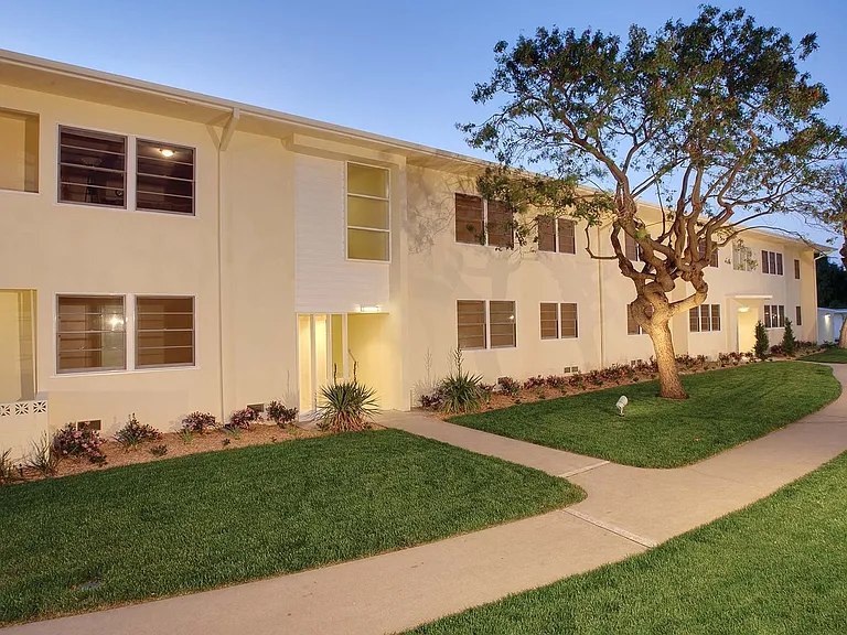 Patterned patio bricks and lush trees surround the community, providing an enjoyable living experience