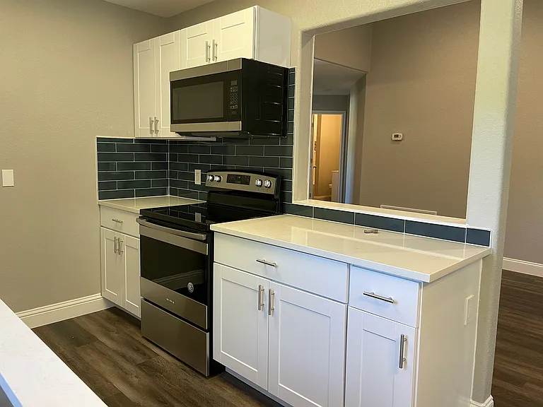 Beautifully remodeled chef's kitchen with quartz counter tops, stainless steel appliances and shaker cabinets