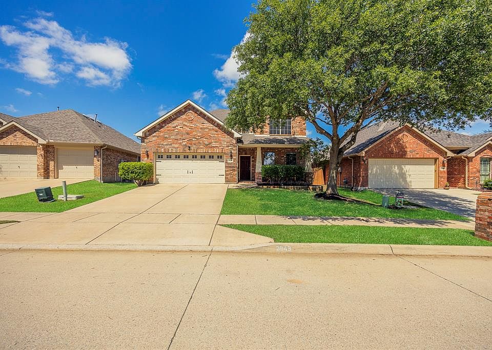 View of front of home featuring brick siding, driveway, a front yard, and an attached garage. All new grass in front yard.