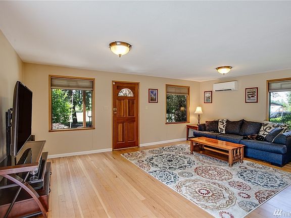 Spacious living room with recently refinished hardwood floors and great natural lighting.