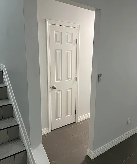 Living Room, Powder Bathroom Door, Hallway, Tile and Grout Flooring, Freshly Painted Ceiling, Doors, Baseboards, Molding and Walls, Stairwell Entry Brand New Tile and Grout with Black Metal Accents.