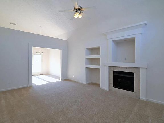 Vaulted ceiling provides openness in living, dining and kitchen. This is view from entrance. Gas fireplace.