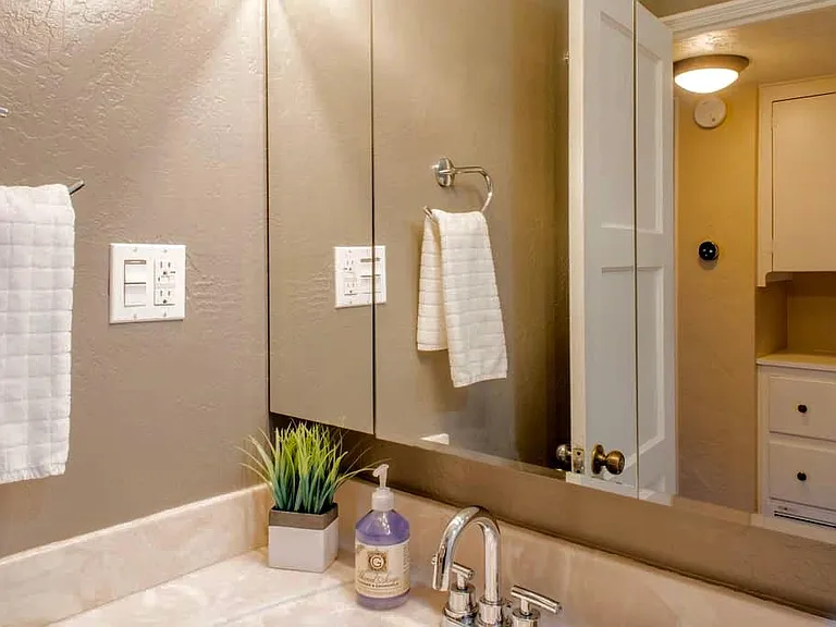 Across from bathroom separate linen closet and cabinets with drawers.