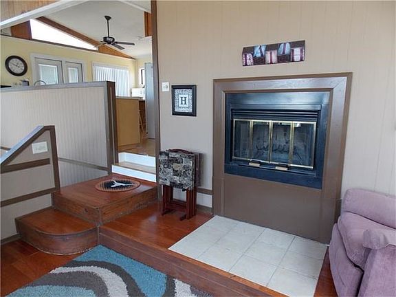 Living room fireplace with kitchen beyond