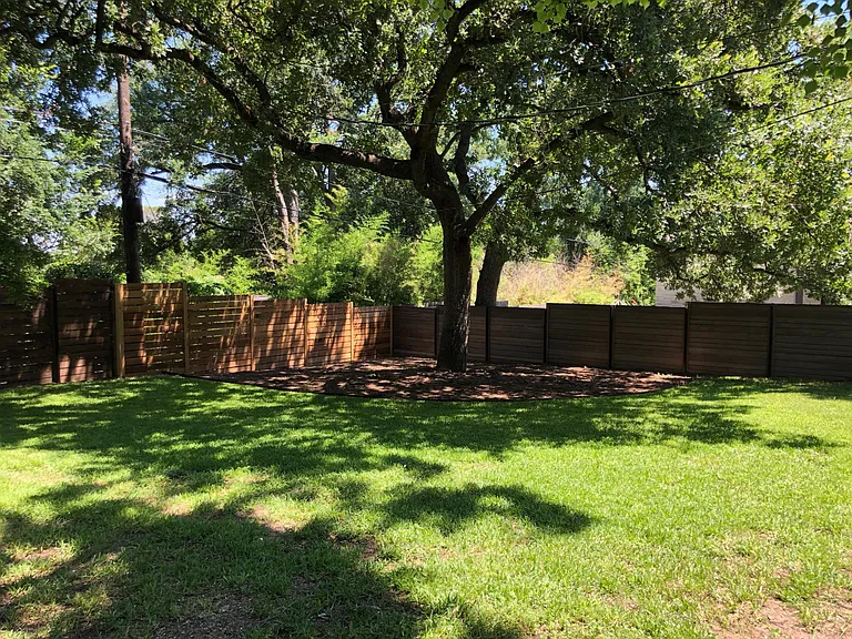 Large, fenced back yard with sprinkler system and lots of shade trees