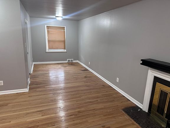 Living room view into the dining room showing refinished hardwood floors.