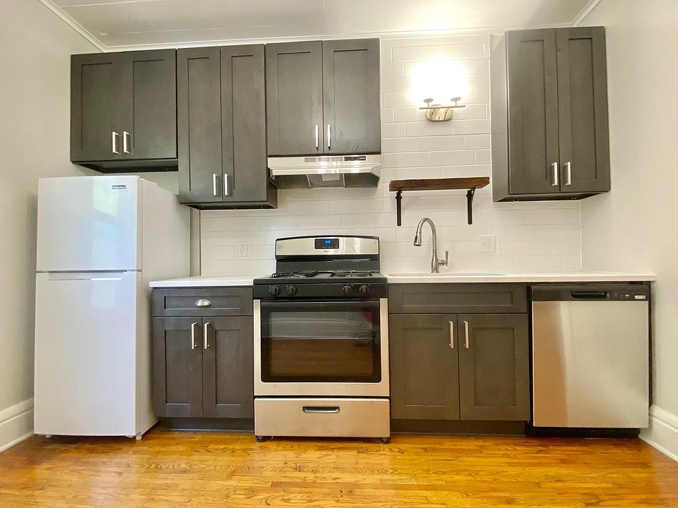 Brand new kitchen with Grey-stone Shaker cabinets, quartz countertops, stainless steel appliances, and subway tile backsplash