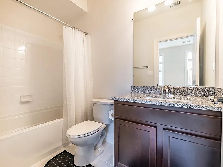 Full bathroom with granite counter top at ground floor bedroom or office