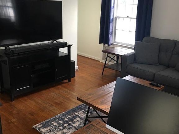 Living room with hardwood floors, unit overlooks a quaint and quiet property