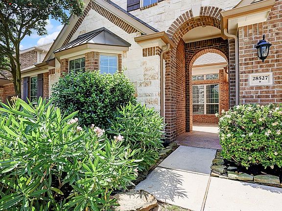 You will enter the home through the double arched stone and brick archways to a private front patio area.
