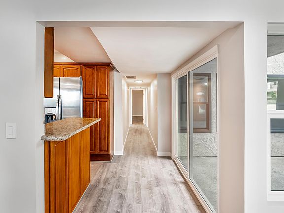 Looking down the hall with the kitchen on the left and patio on the right