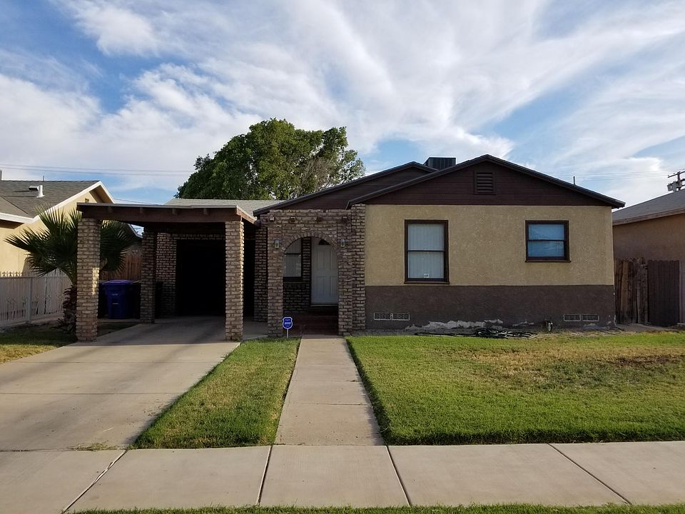 Front of house. Large grassy front yard, attached garage, and covered entrance.