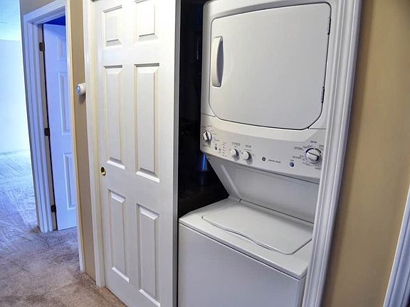 Hallway with washer and dryer and linen closet.