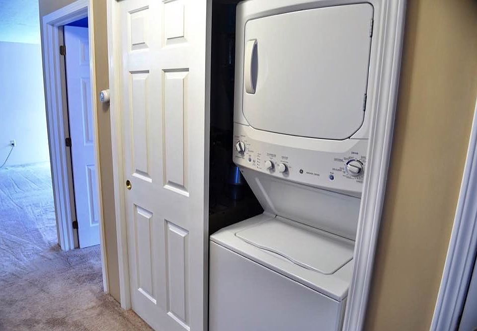 Hallway with washer and dryer and linen closet.