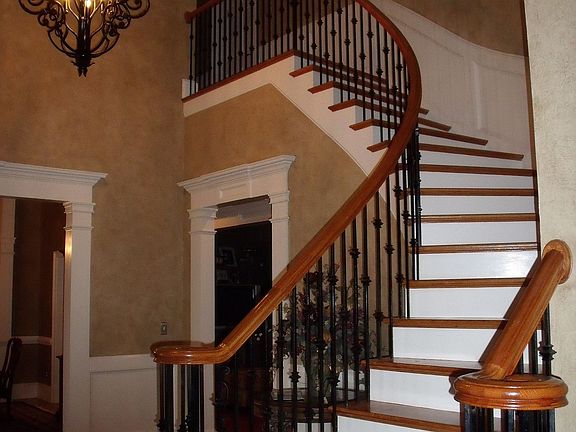 The Entrance Foyer to this Home features a Winding Staircase with Hardwood and