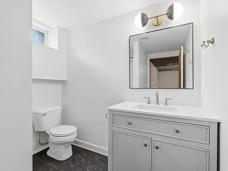 New lower level bathroom. New electrical, lighting, mirror, vanity, faucet, fixtures, toilet, drywall, trim, and LVP flooring.