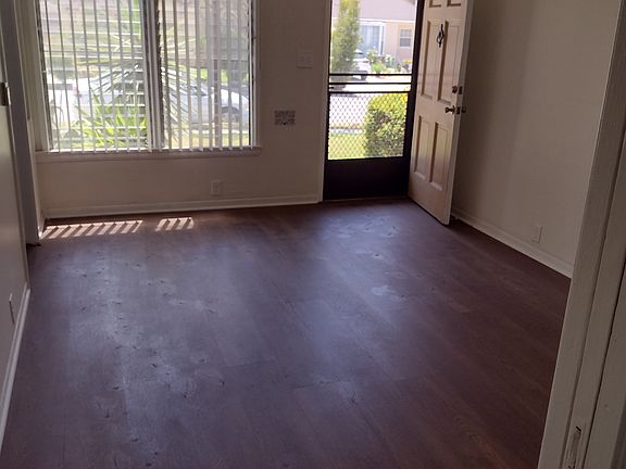 View from a bright and airy living room with newly installed laminated wood flooring throughout the unit.