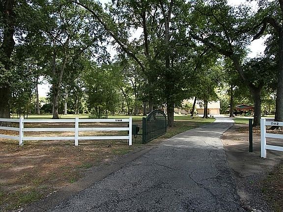  Enter the property with remote access through an electric gate. You are lead to a oversize three car garage with golf cart access too. Access to the second homes attached/detached double car garage is to the right.