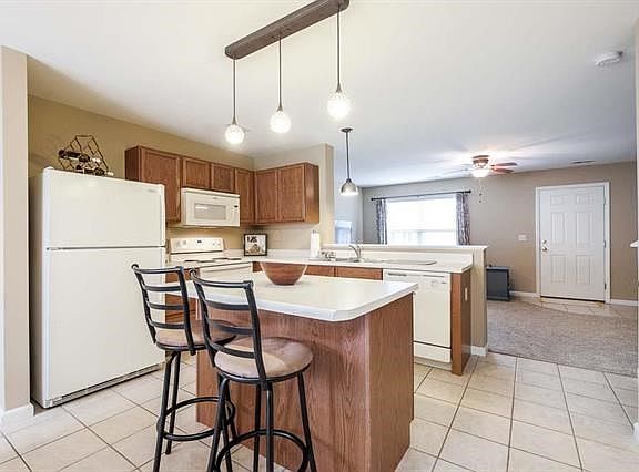 Kitchen area features ceramic tile flooring, center island and plenty of counter space.
