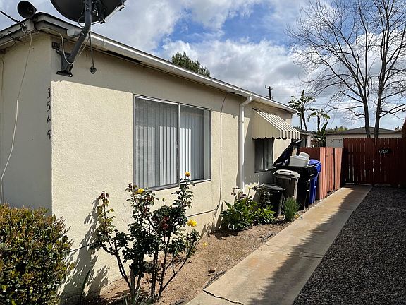 Side yard view. Note that sidewalk leads to the tenants in the back unit.