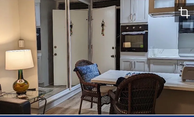 Standing in living room, looking toward the kitchen front door entrance. On left, the kitchen pantry with large mirrored double doors. - 225 Liliuokalani Ave #5D
