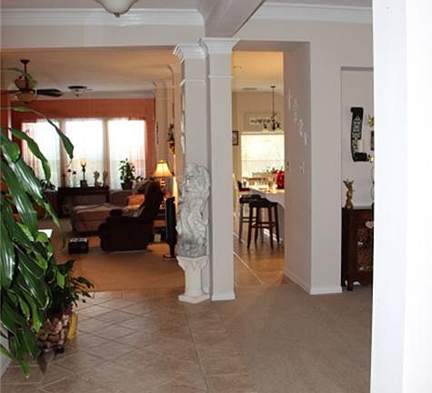 Long entryway upon arriving with tile floors, crown molding, and high ceilings