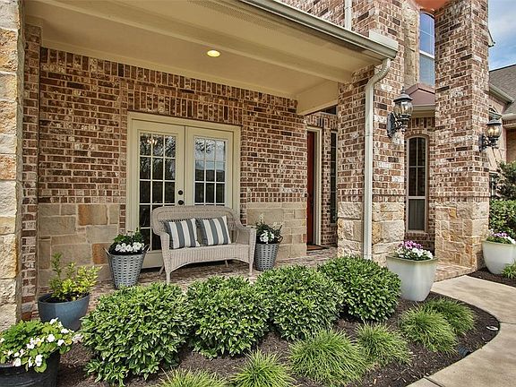Cozy front porch overlooking the front garden. Extensive landscaping package with a variety of shrubs and other plantings.