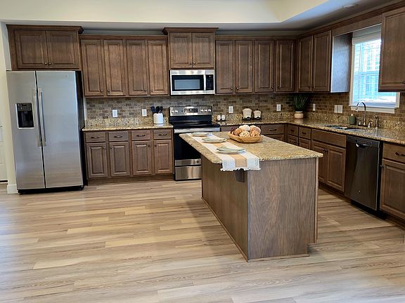 Beautiful open concept kitchen with lots of cabinets including the bar with storage. There is also a separate pantry in the kitchen.