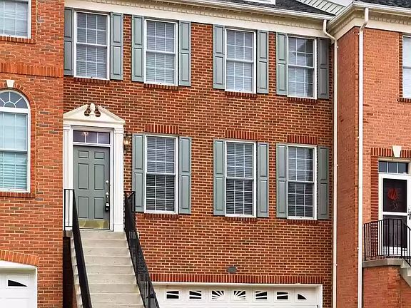Stairs leading to the entrance with a 24 feet two car garage.