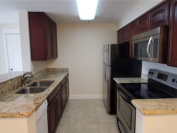 Kitchen with granite counters, undermount sink, SS appliances and tile flooring. 