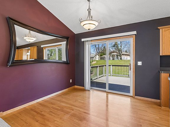 Dining room features hardwood floors, chandelier, and sliding glass door access to the deck and fenced in back yard.