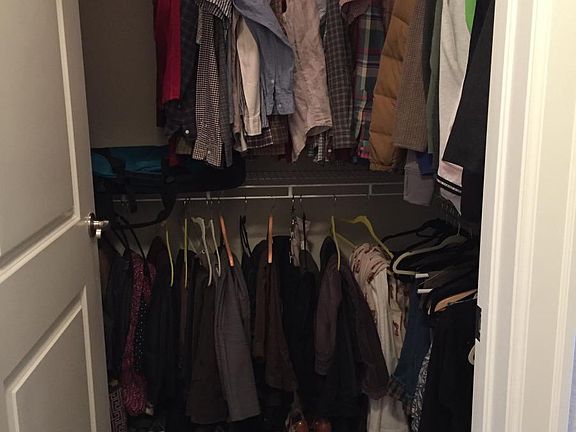 walk in master bedroom closet with hanging racks throughout