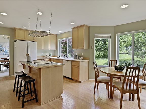 The kitchen is timeless with recessed lighting, lots of cabinet space, classic island with breakfast bar and gorgeous hardwood floors. Look out the windows to a view of Mount Si! Large pantry to hold all your household goods is right in the kitchen.