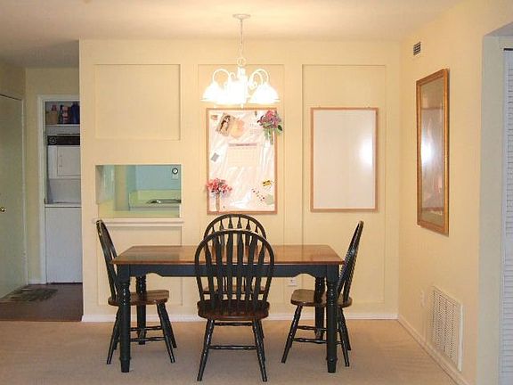 Dining room with view of laundry closet with washer/dryer stacked unit