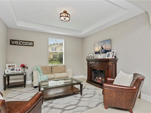 Welcoming formal living room with tray ceiling & decorative electric fireplace. A gorgeous room to relax in!