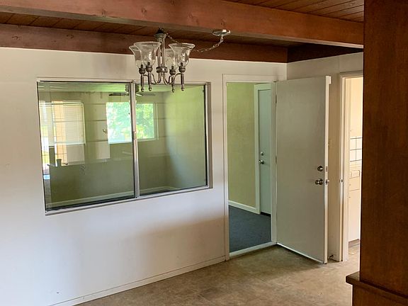 View of dining area. Doorway to left enters into the enclosed patio room. Doorway on right enters into kitchen. Updating to wood floors, new ceiling and wall paint color, and new blinds on windows.