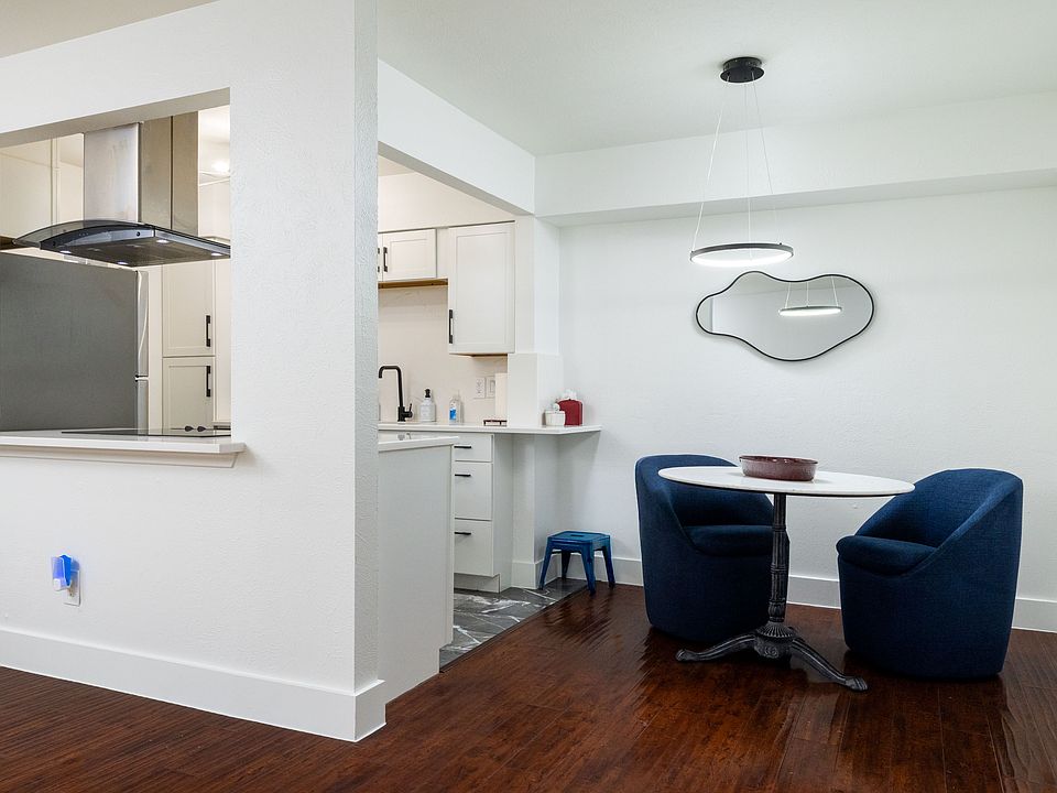 A cozy dining nook with plush navy chairs and a modern round table. Ideal for meals, planning your day, or relaxing with good company.