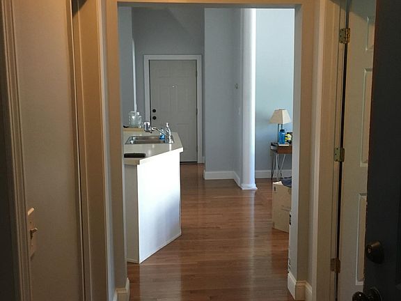 Hall way after entrance opens into kitchen (left), opens int