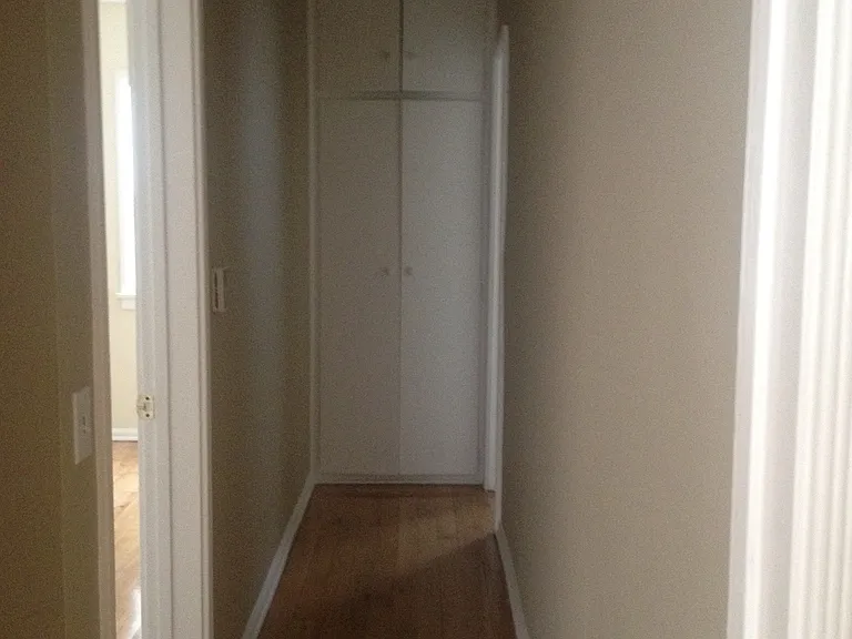 Hallway to bathroom with large closet at end