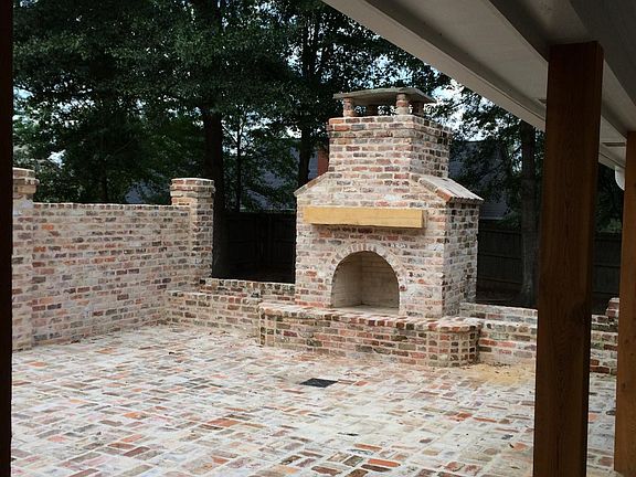 Large outdoor brick courtyard with fireplace