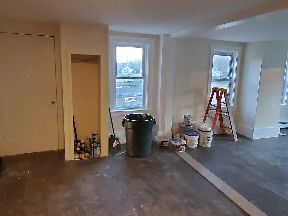 Photo taken of the entry with the living room on the right and back to the kitchen cabinets.
