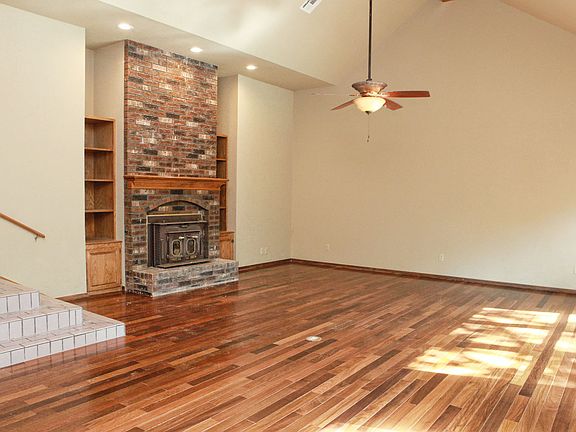 Brick floor-to-ceiling fireplace flanked by built-in bookcases