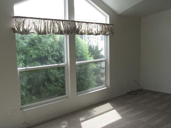 Large living room with cathedral ceilings and beautiful windows through out.