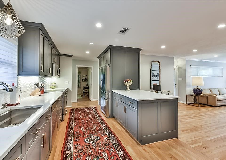 This enviable kitchen design is highlighted with custom cabinets and pantry, Herringbone tile back splash and 3 cm quartz  counter tops.