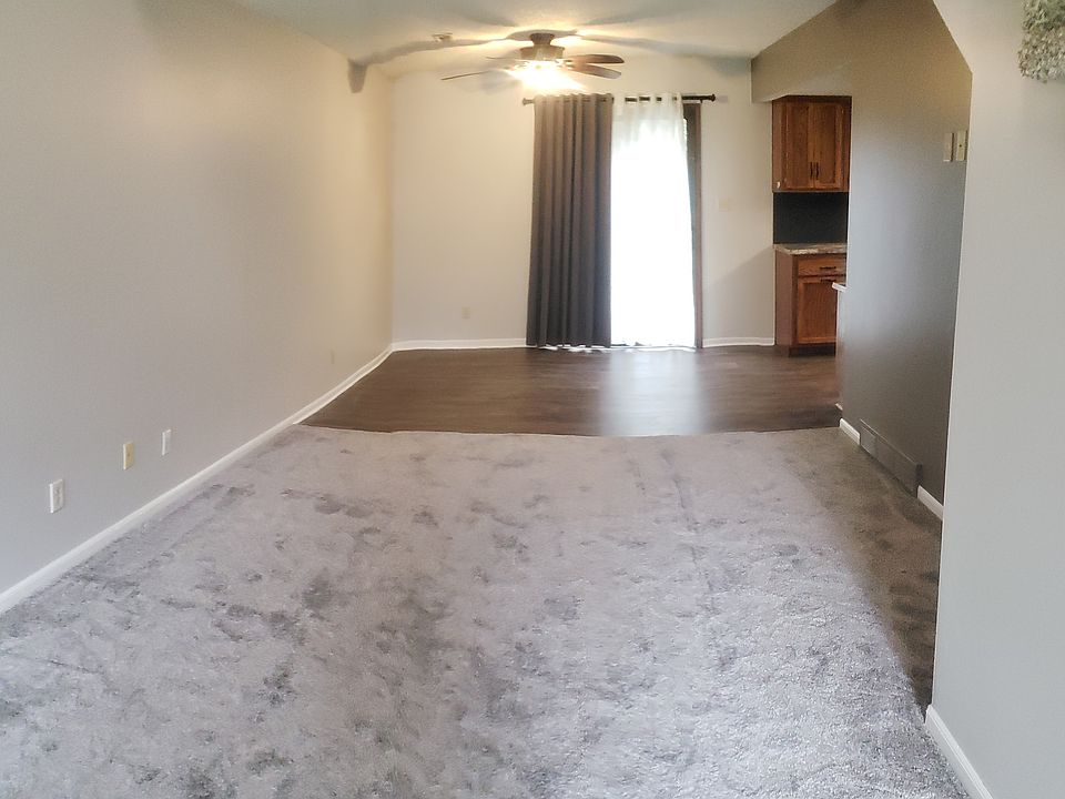 Living room with vaulted ceiling and sky light looking into the dining area.