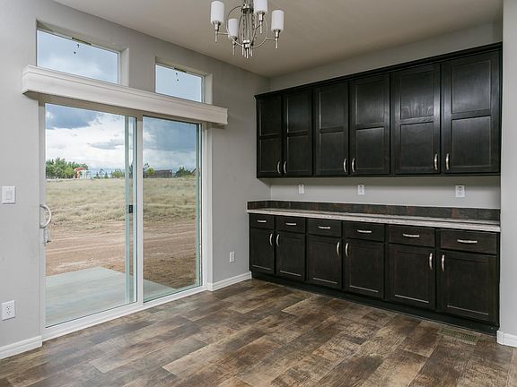 Dining Room - Recessed hard wood cabinets, with upgraded nickel hardware & slate back splash. Transom windows and sliding glass door leads to a very large and spacious rear patio.