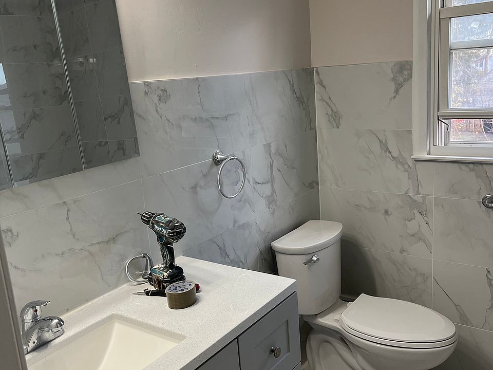 Newly renovated bathroom. New sink, vanity, light fixtures, toilet, and ceramic tiles.
